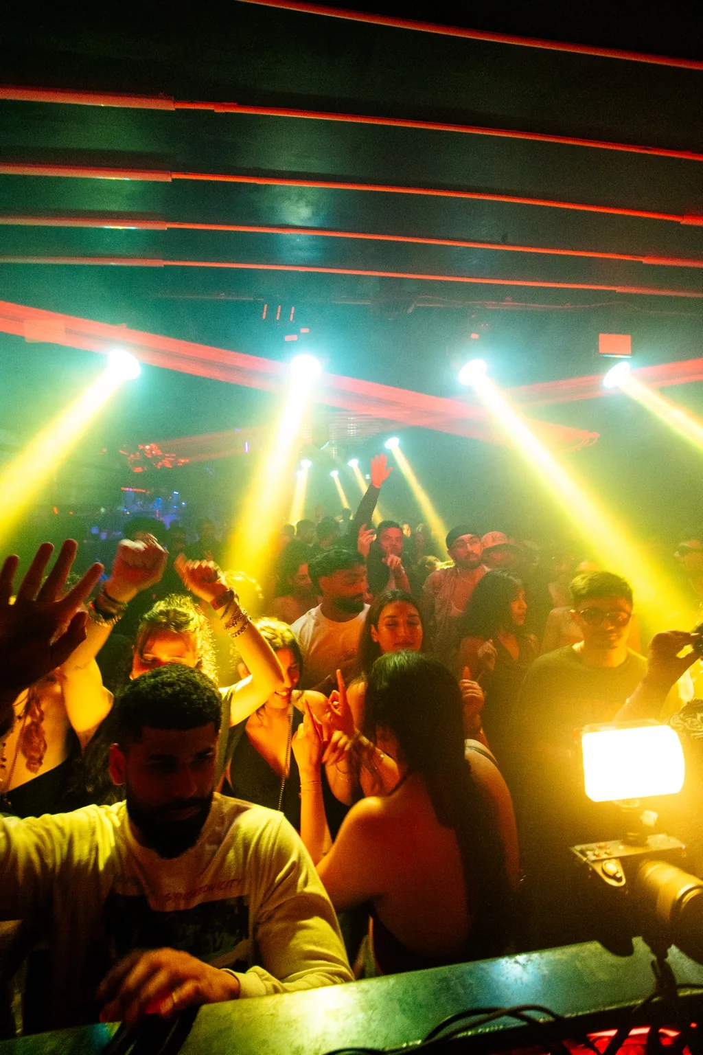 Front row crowd beneath multicoloured stage lights at Project Kulture.