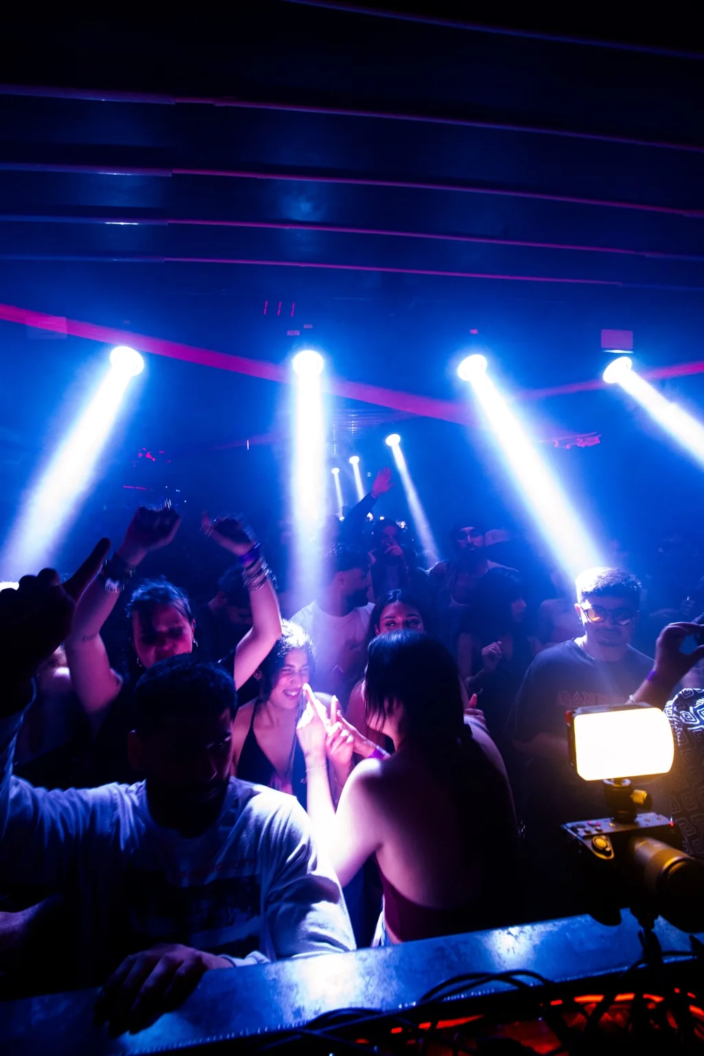 Guests dancing beside the booth under blue lights at Project Kulture.