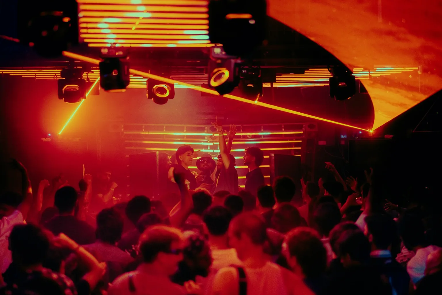 Wide view of a packed dance floor under orange lights at Project Kulture.