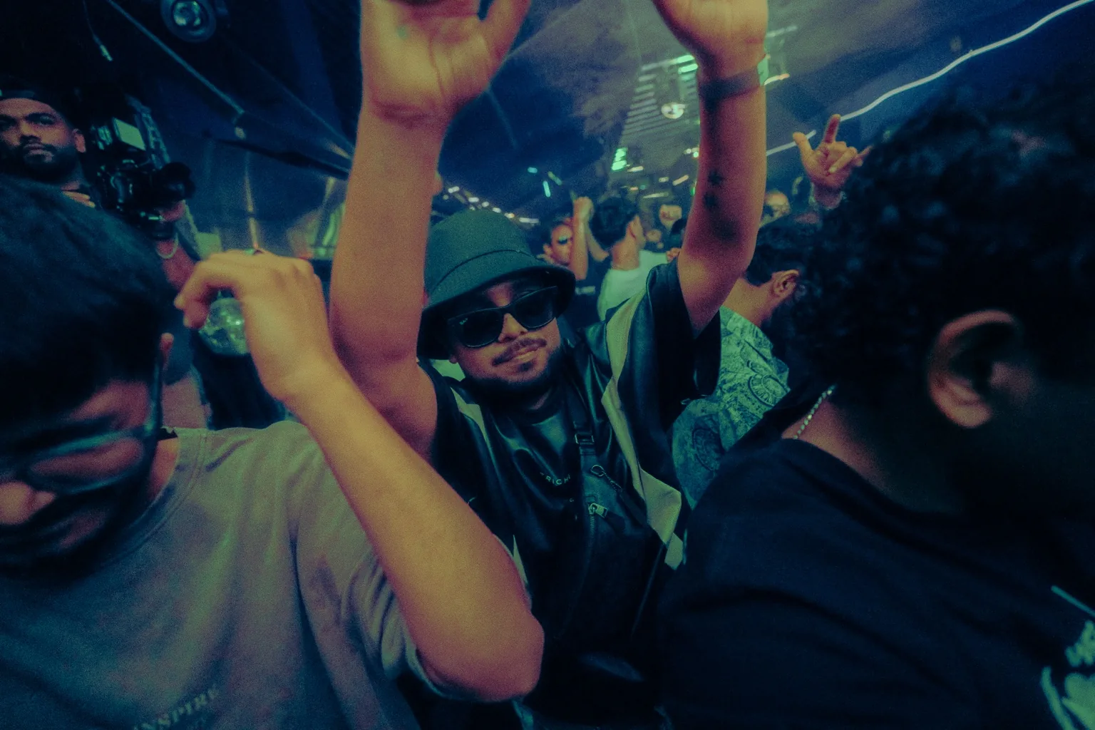 Guest dancing with one arm raised in a crowd at Project Kulture.