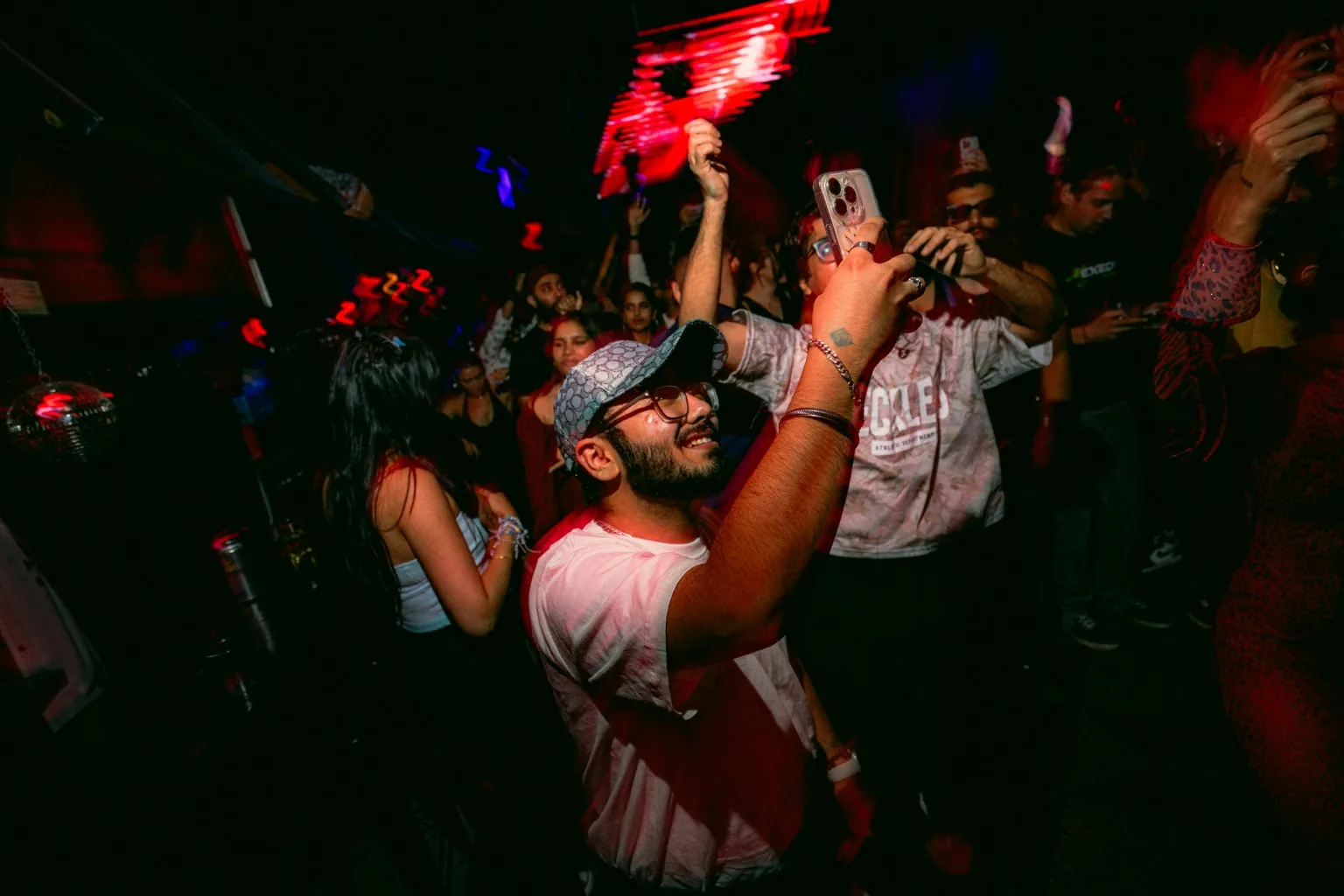 Guest in sunglasses dancing with an arm raised at Project Kulture.