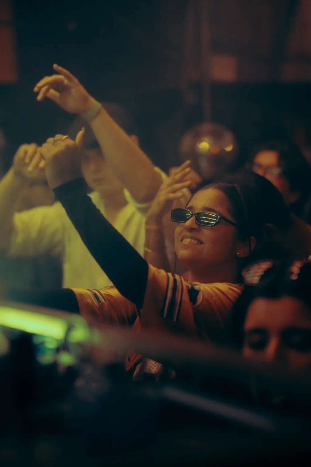 Guest in glasses dancing with arms raised at Project Kulture.