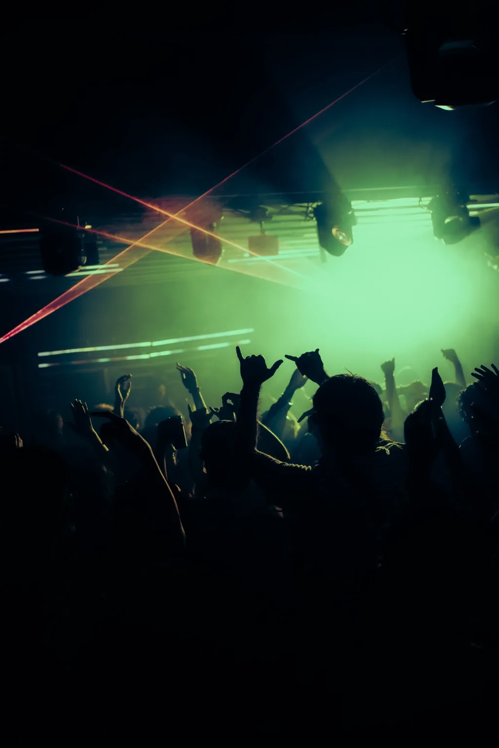 Crowd silhouettes beneath green laser beams at Project Kulture.