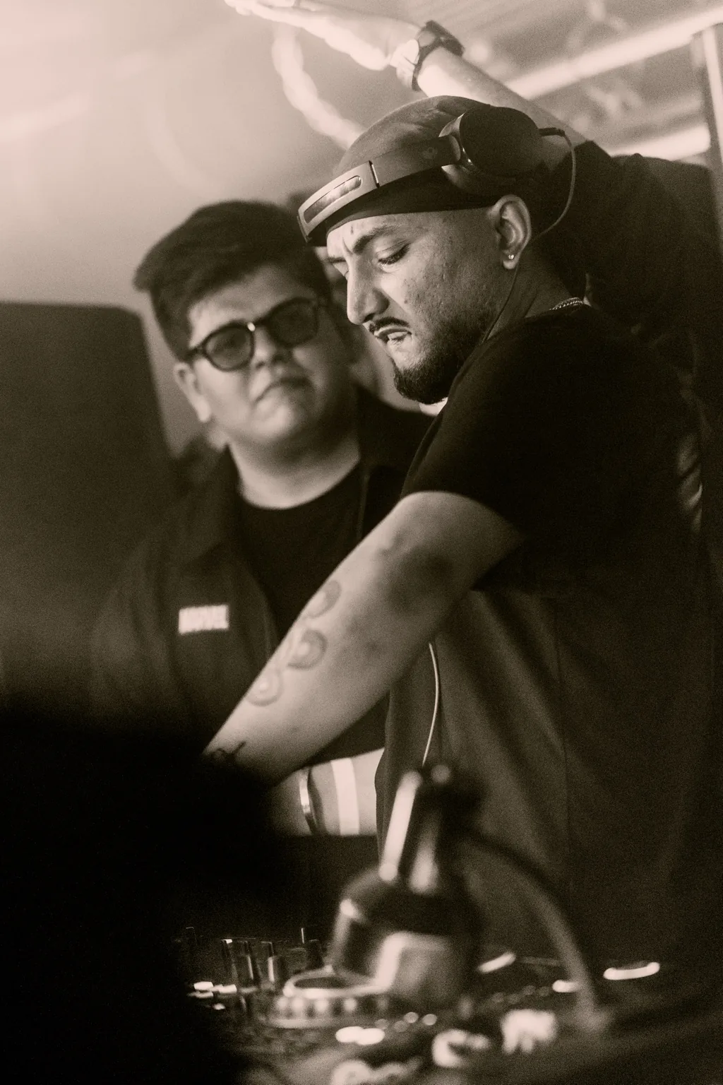 Black and white photo of two DJs at the booth at Project Kulture.