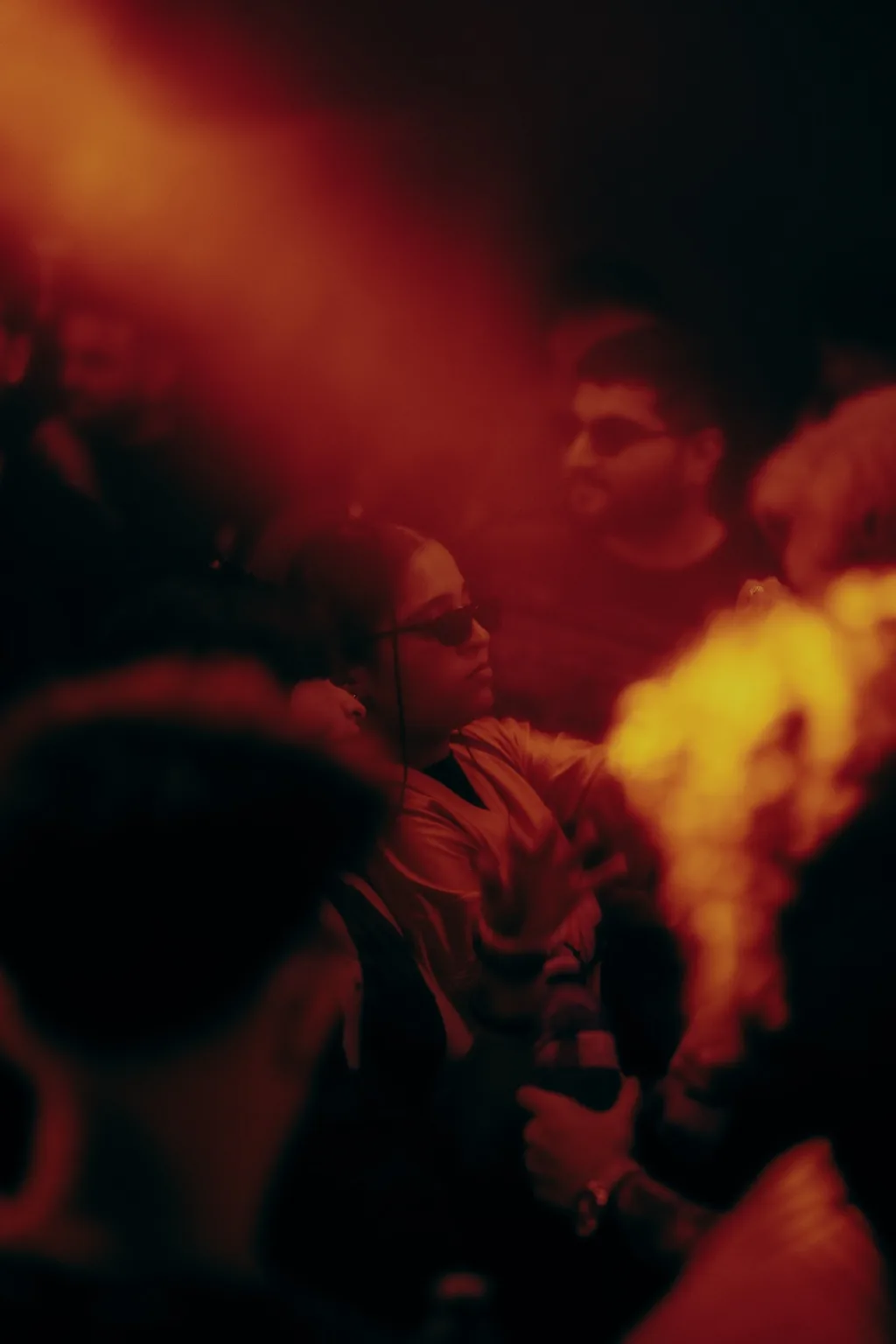 Crowd illuminated by warm red and orange light at Project Kulture.