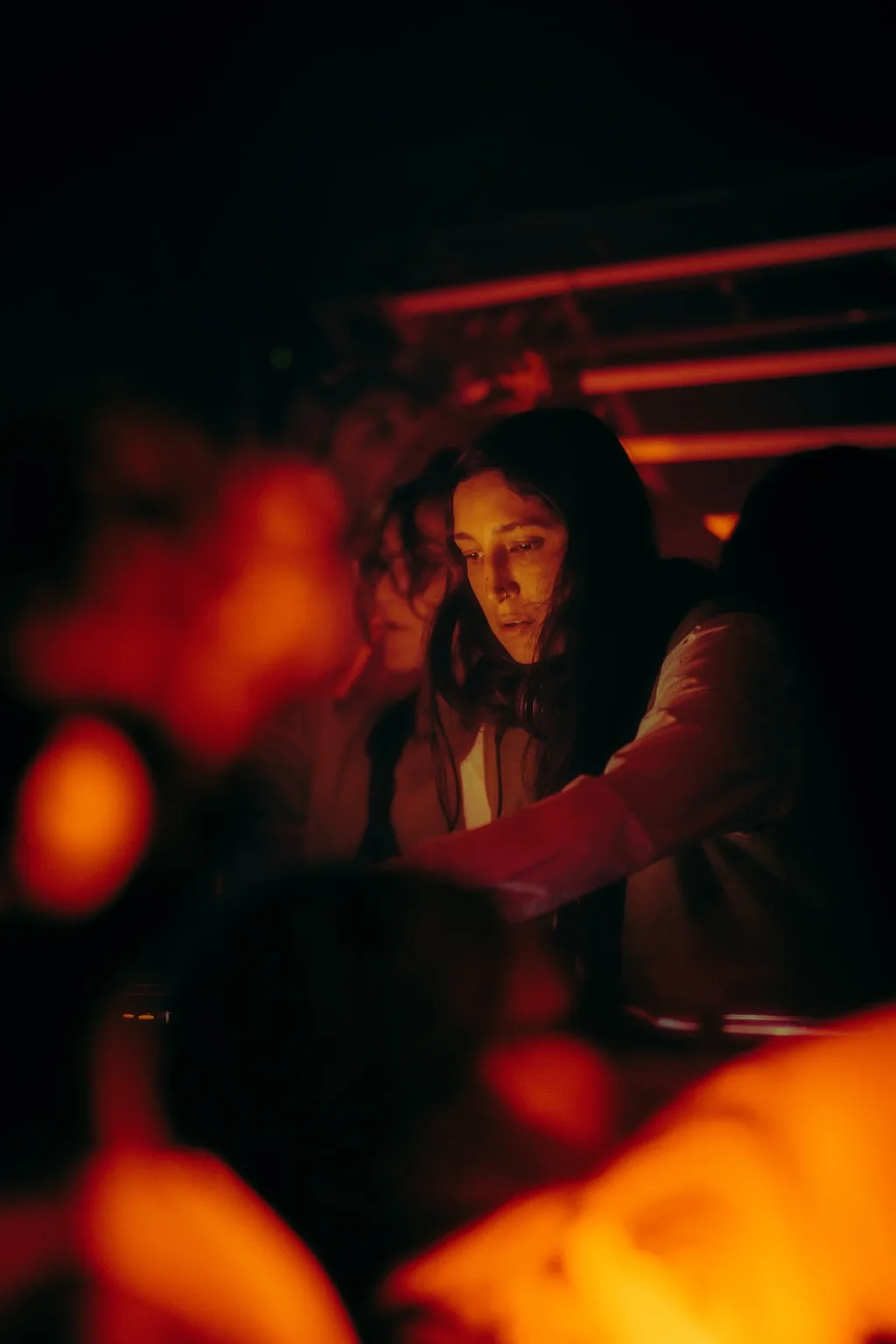 Guest dancing near the booth under red lighting at Project Kulture.